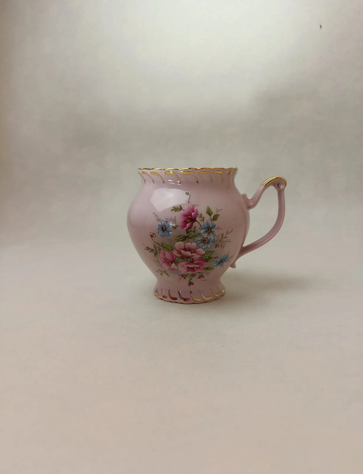 Buclatý hrneček s nožkou z růžového porcelánu s květinovým motivem a zlacením
