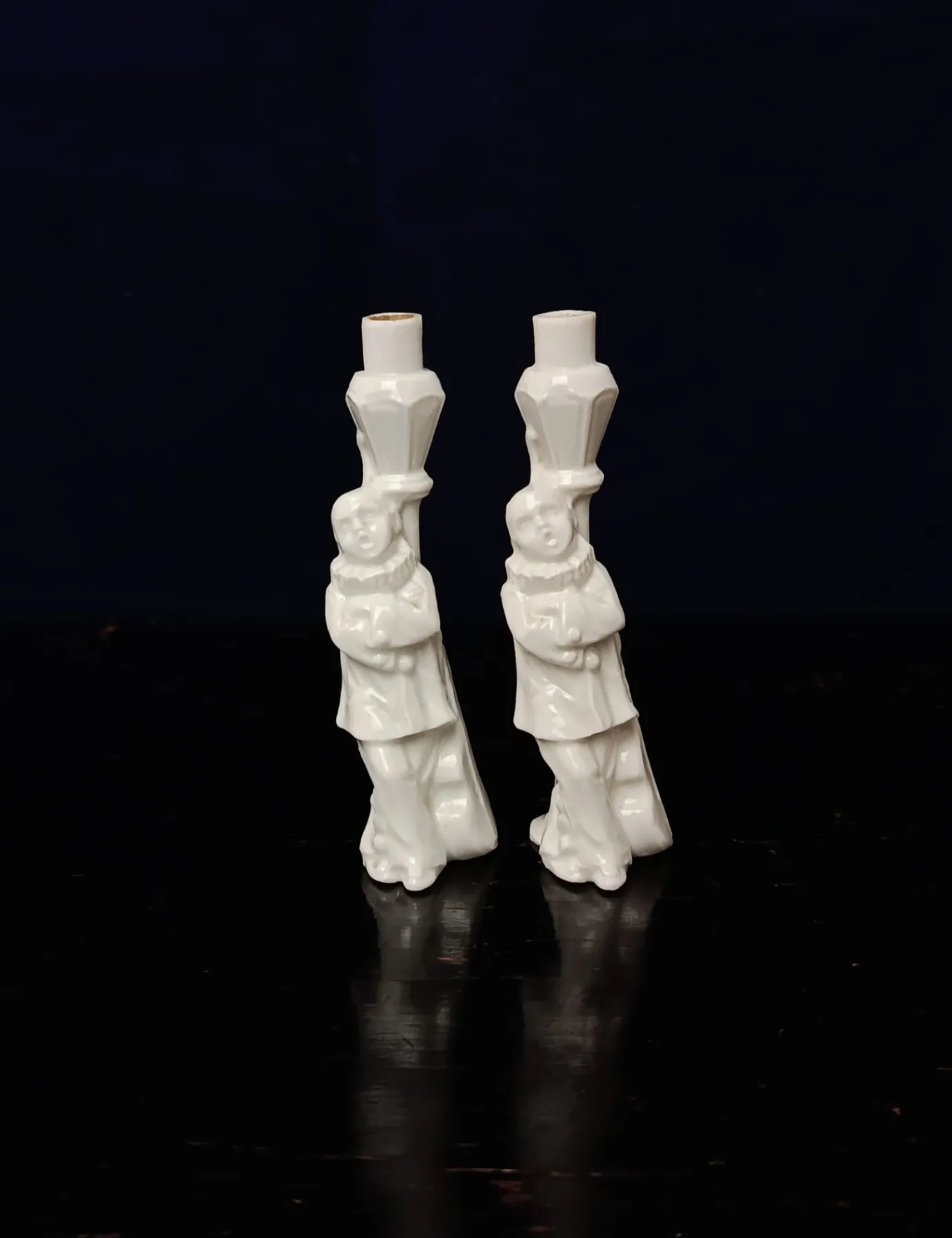 Dvojice figurálních flakónků z bílého porcelánu s motivem harlekýna u pouliční lampy